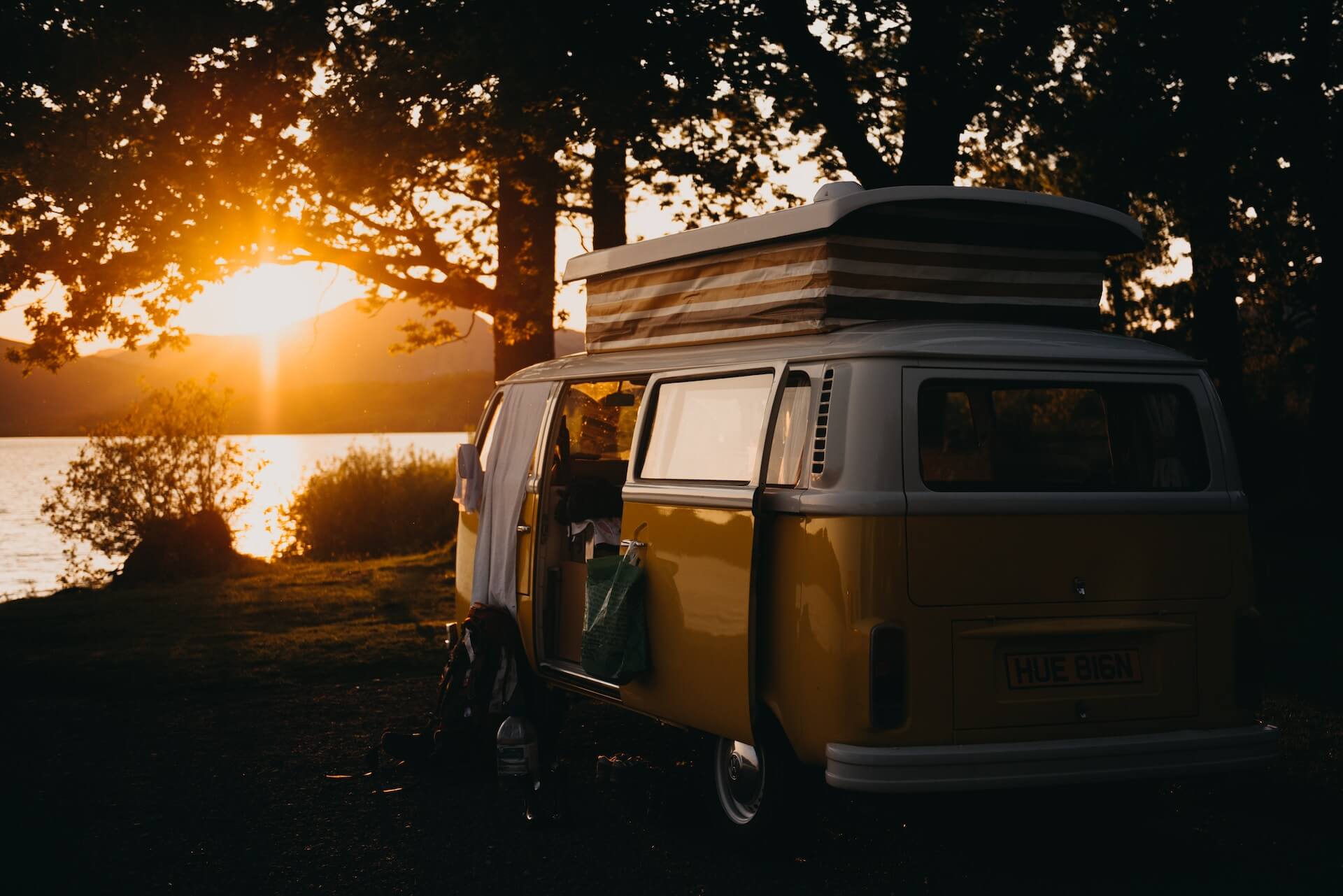 Photo of a campervan next to a lake at sunset